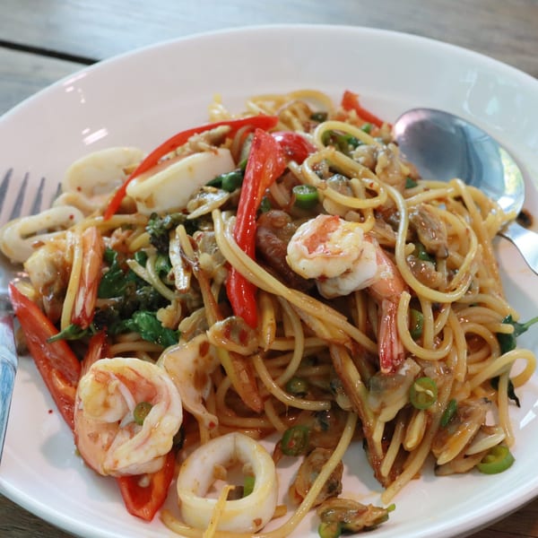 Spicy Indo-Chinese seafood spaghetti with shrimp, squid, clams, red peppers, and green chilies.