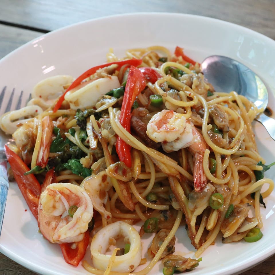 Spicy Indo-Chinese seafood spaghetti with shrimp, squid, clams, red peppers, and green chilies.